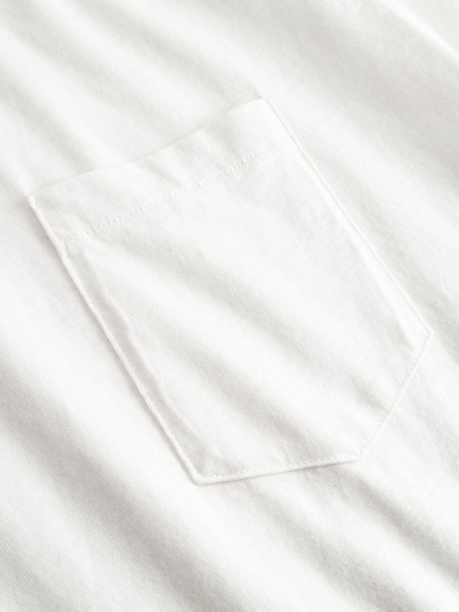 Close-up of the BGoscar T-Shirt - Snow Fall by Blue de Gênes, a white 100% cotton crewneck with a single left chest pocket and subtle edge stitching.
