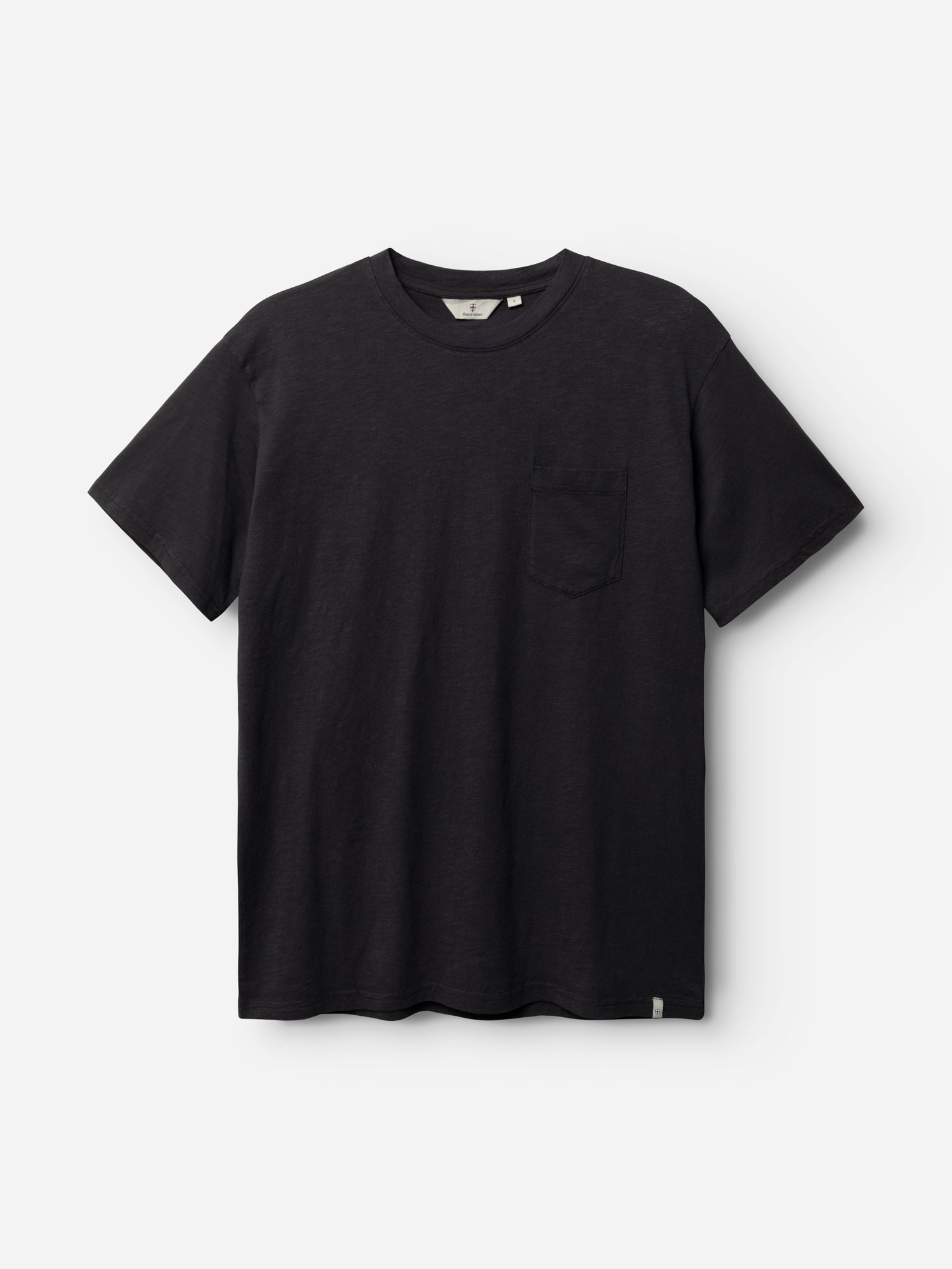 The Blue de Gênes BGoscar T-Shirt - Jet Black is a plain black crewneck short-sleeve tee with a chest pocket, made from 100% cotton and shown against a white background.