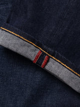 A close-up of the BGvinci Pala Dark V2 Jeans by Blue de Gênes in dark blue denim, crafted in Italy from selvedge fabric, highlighting the folded cuff with red and white stitching and a contrasting yellow seam.