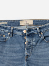 A close-up of the waist and upper part of BGvinci Pala Used V2 Jeans - Denim Blue by Blue de Gênes shows three exposed metallic buttons, an inner label with the brand name, and a small tag indicating made in Italy.