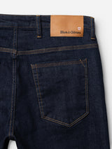 Close-up of the BGrepi Dai V Dark V2 Jeans in dark blue denim by Blue de Gênes, highlighting contrast stitching, a single back pocket, and a tan leather brand patch near the waistband.