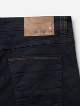 Close-up of the back pocket on BGpaulo Pavia 1 V2 Chino in midnight blue by Blue de Gênes, showcasing contrast stitching, stretch cotton fabric, and a brown leather patch embossed with the brand name and a red and white cross.