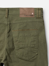 Close-up of the back of Blue de Gênes BGpaulo Pavia 1 V2 Chino - Army, featuring green cotton stretch fabric for comfort and ease of movement. The design showcases a single rear pocket with brown stitching and a tan leather patch embossed with Blue de Gênes and a small red and white crest. Inspired by vintage military pants.