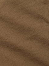 Close-up of the BGpaulo Pavia 1 V2 Chino - Fudge by Blue de Gênes, featuring brown fabric with a diagonal weave and subtle creases that highlight its textured, cotton stretch construction.