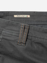 Close-up of the waistband of charcoal BGpaulo Pavia 1 V2 Chino pants by Blue de Gênes, featuring brown stitching on cotton stretch fabric and a label with "Made in Italy" beside a small Italian flag.