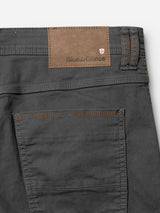 Close-up of the back pocket of BGpaulo Pavia 1 V2 Chino in charcoal by Blue de Gênes, made from cotton stretch fabric, featuring brown stitching and a tan leather patch with brand label plus a small emblem in the corner.