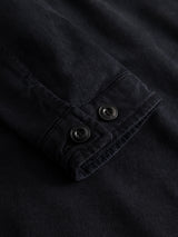Close-up of a navy BGbarnaba Iro Overshirt sleeve by Blue de Gênes, featuring two black buttons on the cuff and highlighting the texture and stitching of the fabric.