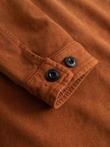 Close-up of the BGbarnaba Iro Overshirt in Ginger Bread Orange by Blue de Gênes, showcasing the soft comfort fabric sleeve with black buttons and visible stitching details for a workwear-inspired look.