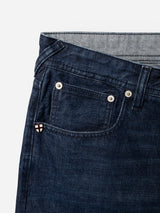 Close-up of the front pocket area of BGgiacomo Arthour Jeans – Denim Blue by Blue de Gênes, featuring durable dark blue comfort stretch denim in a relaxed loose fit. Visible are metal rivets, intricate stitching details, and a small patch with the brand’s signature red and white cross logo on the coin pocket. These jeans deliver both resilience and everyday comfort.