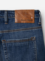 Close-up of the back pocket of the BGrepi Callum Jeans in mid blue denim by Blue de Gênes, crafted from comfort stretch denim and featuring a brown leather patch embossed with the brand name and a small stitched shield logo above the pocket.