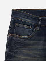 Close-up of the front pocket area of the BGvinci Finlay Jeans - Vintage Wash by Blue de Gênes, showcasing visible stitching and a small patch with a red cross on a white background near the coin pocket.