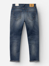 A pair of Blue de Gênes BGvinci OM Jeans in a denim wash is shown from the back, highlighting visible rear pockets, faded and distressed detailing, rolled cuffs, and patch accents on the waistband for an authentic worn-in appearance. These regular fit jeans offer classic five-pocket styling for a timeless look.