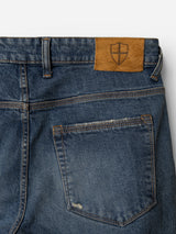 Back pocket of BGrepi Presley Jeans - Denim Blue by Blue de Gênes, crafted from comfort stretch denim with a brown leather patch above featuring a shield emblem.