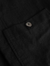Close-up of the BGduncan Ian Gilet in black by Blue de Gênes, highlighting the pocket with a single black button, fine stitching, and lightweight linen fabric with a textured finish.
