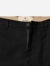 Close-up of the waist area of the BGpalco Ian Pant in black by Blue de Gênes, featuring a relaxed fit with a button and partially unzipped fly, revealing a beige inner waistband with a Blue de Gênes label.