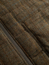 Close-up of the BGalec Skotch Waistcoat - Brown Check by Blue de Gênes, showcasing its brown check tweed fabric with a subtle plaid pattern. The waistcoat features corduroy panels and a metal zipper running diagonally along the left side, with the texture and stitching details of the material clearly visible.