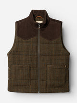 The BGalec Skotch Waistcoat - Brown Check by Blue de Gênes is a brown checkered vest made from wool, featuring corduroy shoulder panels, front pockets, and a hanging loop inside the collar, shown against a white background.
