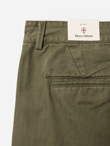 Close-up of the BGmenzo Rory Chino - Army by Blue de Gênes, showcasing olive green washed herringbone fabric with a subtle pattern, a single back pocket, and a signature Blue de Gênes tag near the waistband. This design embodies the classic chino fit.
