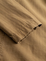 Close-up of the BGgabbiano Rory Blazer in khaki by Blue de Gênes, featuring brown washed herringbone fabric with a folded sleeve that highlights intricate stitching and rich texture—ideal for a relaxed, unconstructed design.