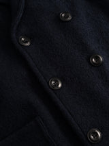 Close-up of the BGlewis Wool Blazer in Dark Navy by Blue de Gênes, featuring black buttons and a visible pocket seam that highlight the textured boiled wool fabric and refined button details, exemplifying relaxed tailoring.