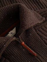 Close-up of the BGcallum Zip Knit in Hot Fudge Brown by Blue de Gênes—a chunky rib-knit wool sweater with a half-zip, finished with a leather zipper pull and featuring a visible Blue de Gênes label inside the collar.