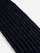 A detailed close-up of the BGcomforto Knit Scarf in Dark Navy by Blue de Gênes, showcasing its ribbed knit texture, photographed diagonally on a white background.