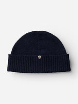 The BGboshi Beanie - Dark Navy by Blue de Gênes is a dark navy wool beanie with a ribbed turn-up cuff and a small shield-shaped emblem on the front center of the cuff, shown against a plain light background.