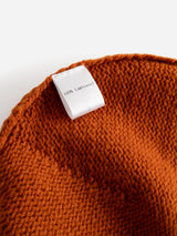 A close-up of the BGboshi Beanie in Ginger Bread Orange by Blue de Gênes, featuring orange knitted fabric with a ribbed turn-up and a white tag that reads 100% Lambswool.