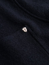 A close-up of the BGhew Wool Overshirt in dark navy by Blue de Gênes, detailed with a small shield-shaped pin featuring a cross design in white and gold.