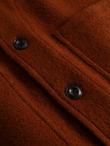 Close-up of the BGhew Wool Overshirt in Ginger Bread Orange by Blue de Gênes, showing two black buttons and seams on the textured brown felted wool fabric.