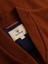 Close-up of the BGmudock Wool Waistcoat in Ginger Bread Orange, featuring a Blue de Gênes label stitched to the navy blue fabric lining, evoking the look of classic workwear-inspired vests.