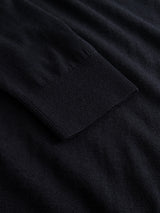 A close-up of the sleeve of the Blue de Gênes BGhamish Crewneck Knit in Dark Navy, featuring a ribbed cuff, laid flat on a matching dark navy background.