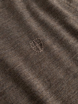A close-up of the Blue de Gênes BGhamish Crewneck Knit in Sepia Tint Brown shows a visible oval-shaped patch of hand-stitched mending at the center, featuring neat, small stitches that contrast slightly with the surrounding lightweight knit material.