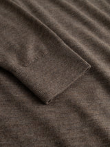 Close-up of the BGhamish Crewneck Knit in Sepia Tint Brown by Blue de Gênes, featuring the sleeve laid flat on matching fabric to highlight its textured knit and ribbed cuff detail.