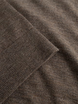 Close-up of the BGhamish Crewneck Knit in Sepia Tint Brown by Blue de Gênes, highlighting the lightweight knit fabric’s texture and pattern with a ribbed edge folded over the flat surface, reminiscent of a classic merino wool sweater.