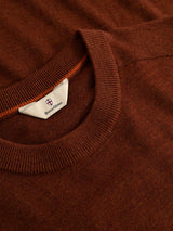 A close-up of a ginger bread orange lightweight knit crewneck sweater with a ribbed neckline and a Blue de Gênes label visible inside the collar, featuring the BGhamish Crewneck Knit design.