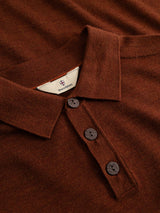 A close-up of the Blue de Gênes BGigor Polo Knit in Ginger Bread Orange, featuring fine-gauge knit fabric, a folded collar, three dark buttons, and a visible white inner label.