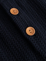 Close-up of two round brown buttons on the dark, textured fabric of the BGmurry Polo Knit in Dark Navy by Blue de Gênes.