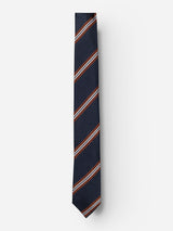 The BGcarl Tie - Dark Navy by Blue de Gênes is a luxurious navy blue accessory adorned with bold red and white diagonal stripes, beautifully showcased against a plain white background.