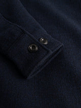 Close-up of the BGdugal Bomber Jacket by Blue de Gênes in dark navy, highlighting the sleeve with two black cuff buttons and showcasing the textured wool blend fabric.