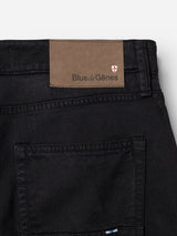 Close-up of the back pocket and waistband of navy BGvinci Iro Pants by Blue de Gênes, crafted from comfort stretch twill for ease of movement, featuring a brown Blue de Gênes label and a small red and white shield logo positioned above the pocket.