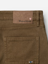Close-up of the back pocket of beech green pants crafted from comfort stretch twill, featuring a Blue de Gênes leather patch and a small crest logo above the pocket. The BGvinci Iro Pant by Blue de Gênes blends classic detailing with modern comfort in a regular fit style.