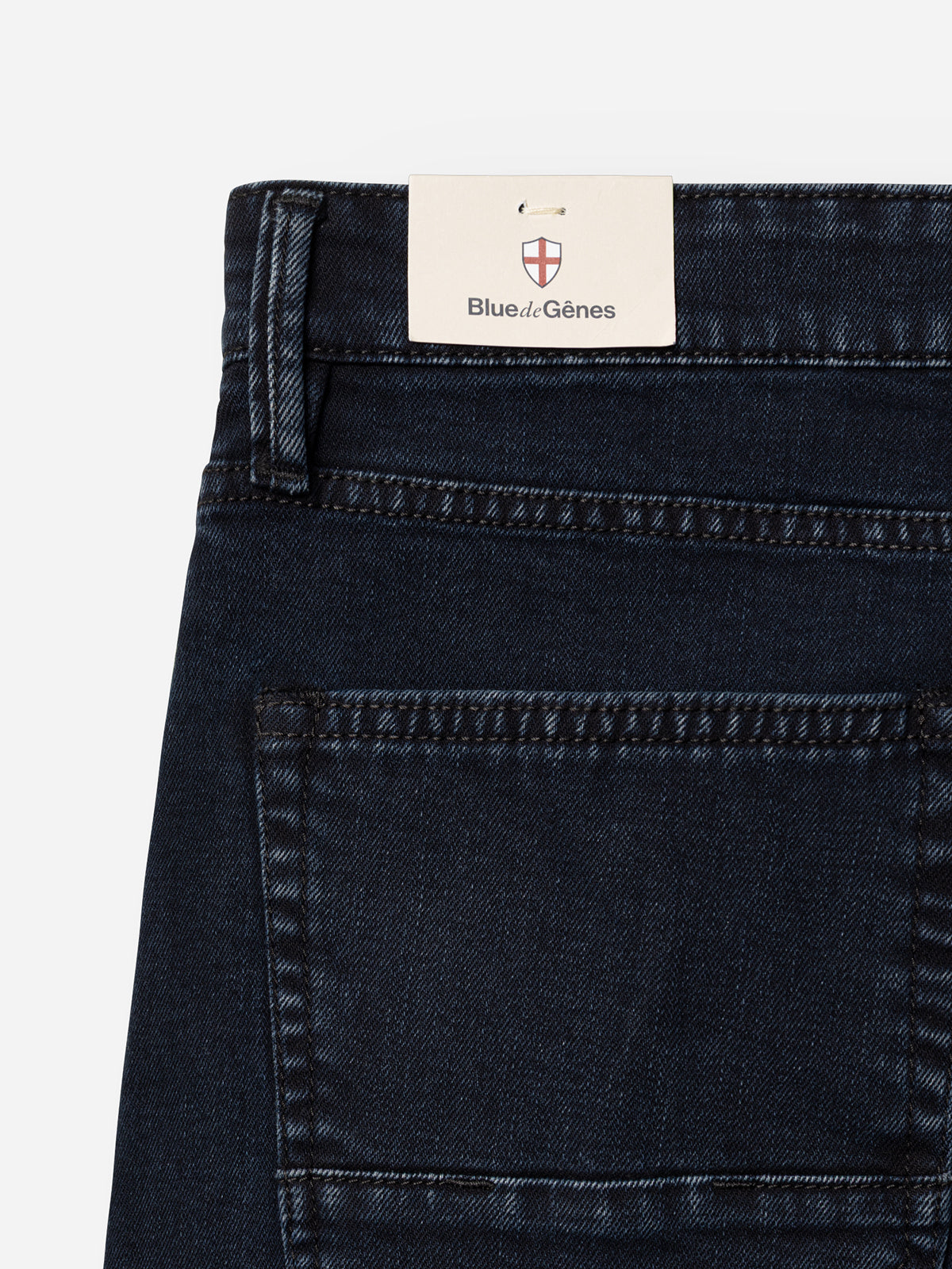 Close-up of the back pocket and waistband of Blue de Gênes BGvinci Black OD Jeans in blue-black denim, featuring a rectangular brand tag above the pocket.