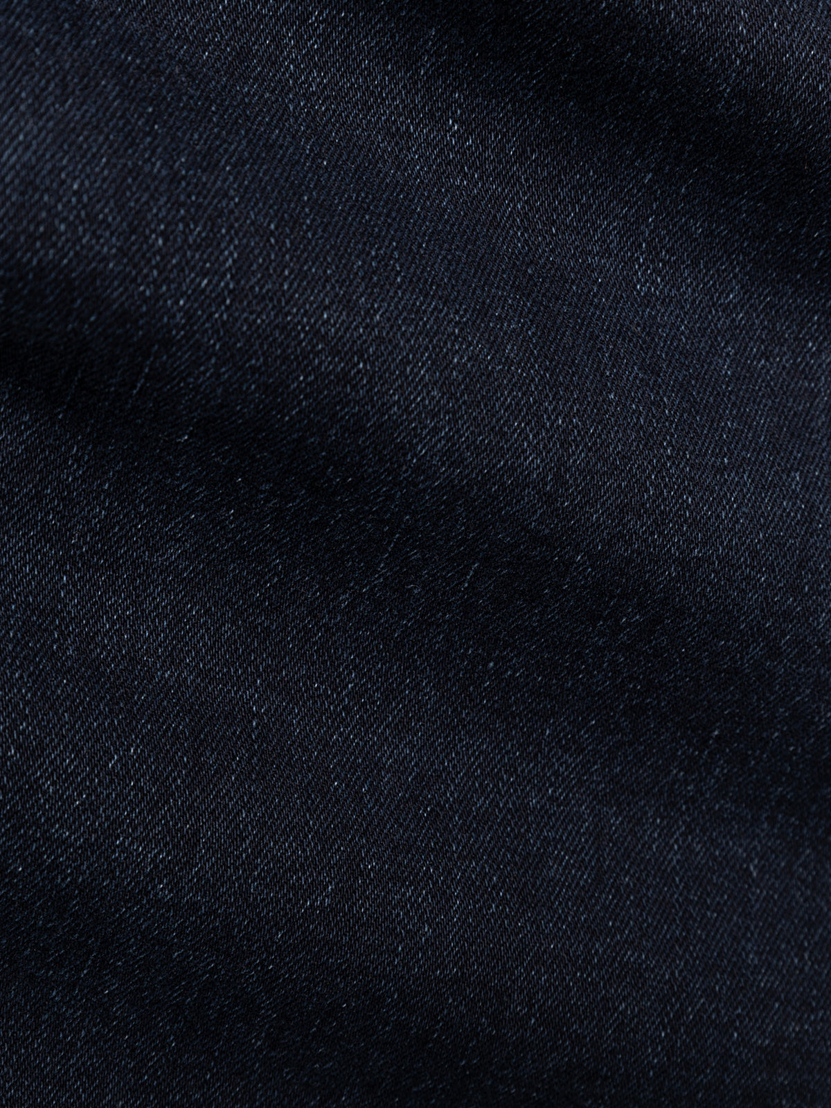 Close-up of BGvinci Black OD Jeans in blue black denim from Blue de Gênes, showcasing the comfort stretch fabric's texture, weave details, and subtle variations in color and shading.