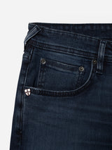 Close-up of the front pocket area of Blue de Gênes BGgiacomo BB Jeans in blue black denim, highlighting a small shield-shaped metal embellishment on the coin pocket. These relaxed loose fit jeans are crafted from rigid denim for lasting style and comfort.