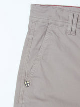 Close-up of the upper section of the BGpaulo Teo Pant in Flint gray by Blue de Gênes, featuring the waistband, belt loop, front pocket, and a small triangular logo near the pocket—an updated take on vintage military pants crafted into durable chinos.