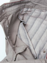 A close-up of the inside of a gray jacket showing snap buttons and a gray-and-white striped fabric lining, reminiscent of the robust construction found in vintage military pants or durable chinos such as the BGpaulo Teo Pant in Flint gray by Blue de Gênes.
