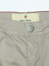 Close-up of the waistband and button of the BGpaulo Teo Pant in Shadow Green by Blue de Gênes. The label displays the Blue de Gênes name with a red and white shield logo above it, evoking vintage military styling. The button also bears the distinctive shield logo, highlighting the brand's meticulous attention to detail and commitment to quality craftsmanship in their chinos.