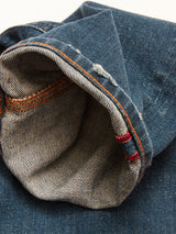 Close-up of the cuff of the Blue de Gênes Vinci Topaz Vintage Jeans - Used, made in Italy, highlighting the inside seam with orange stitching and a touch of red thread detail. The comfort stretch denim fabric shows subtle wear and fading.