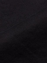 Close-up of black comfort stretch twill fabric with a diagonal fold, displaying the fine ribbed texture and tightly woven threads—ideal for Blue de Gênes Vinci Venom Blk Jeans - Dark Denim, expertly crafted in Italy.